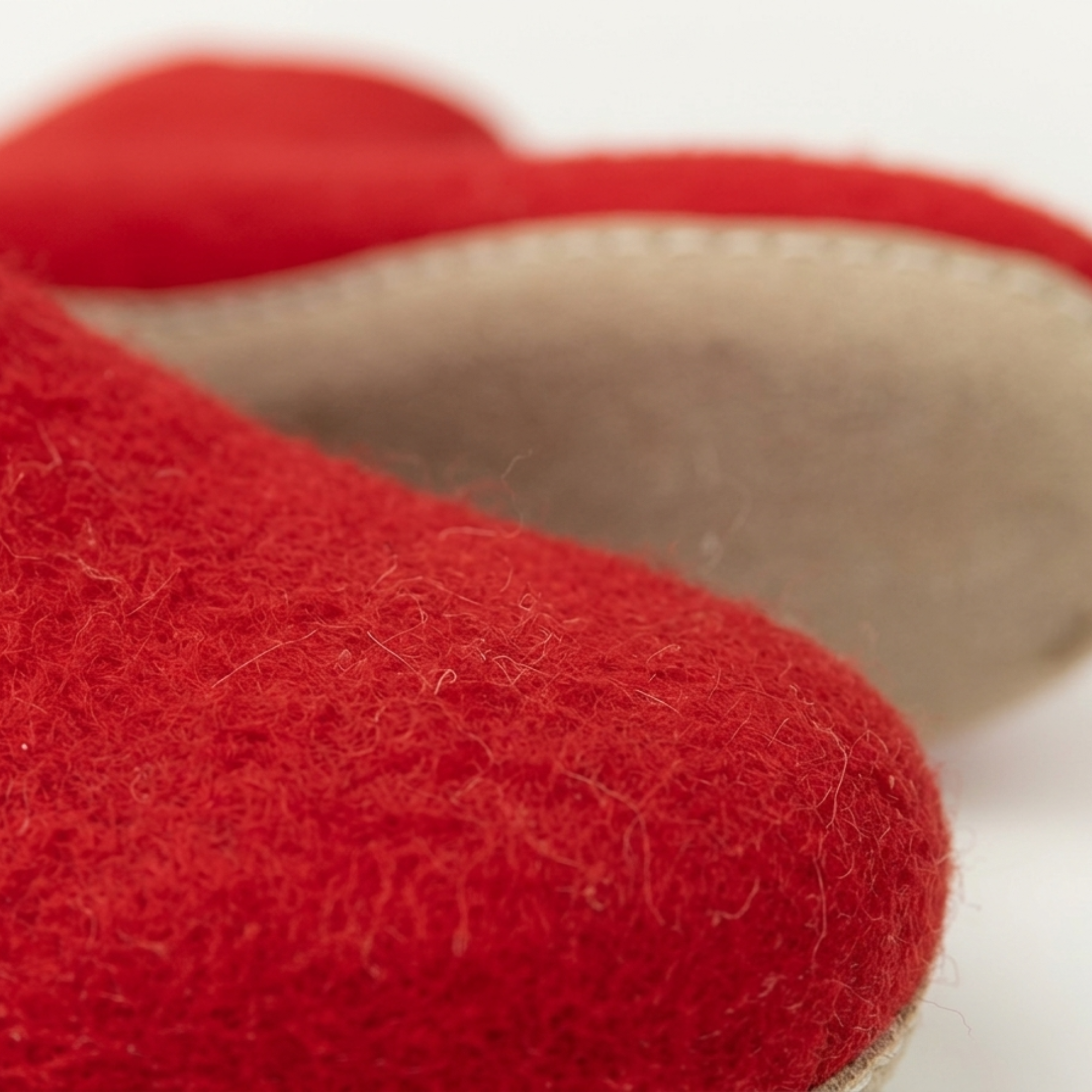 A close-up texture image showing the dense and soft surface of felted wool used in footwear.